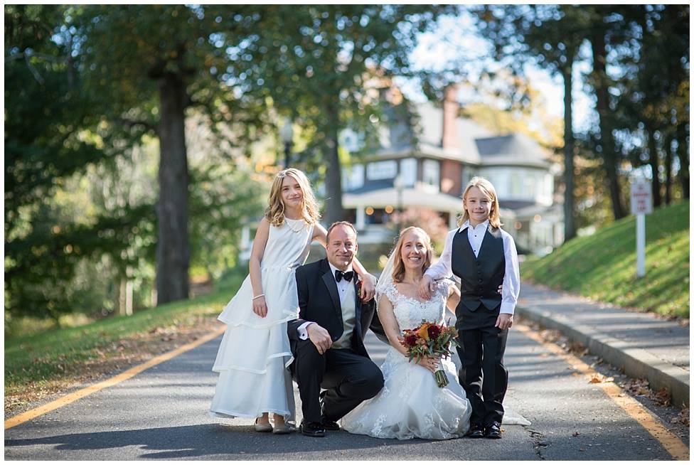 bride, groom and kids in front of mansion