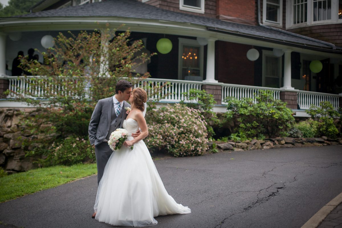 bride and groom kissing in front of the decorated veranda