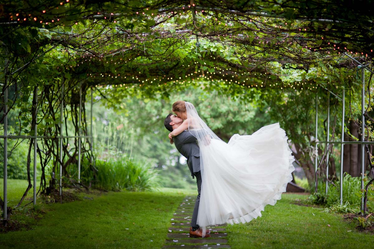 high-school-sweethearts-wed-groom-lifting-bride-in-a-kiss