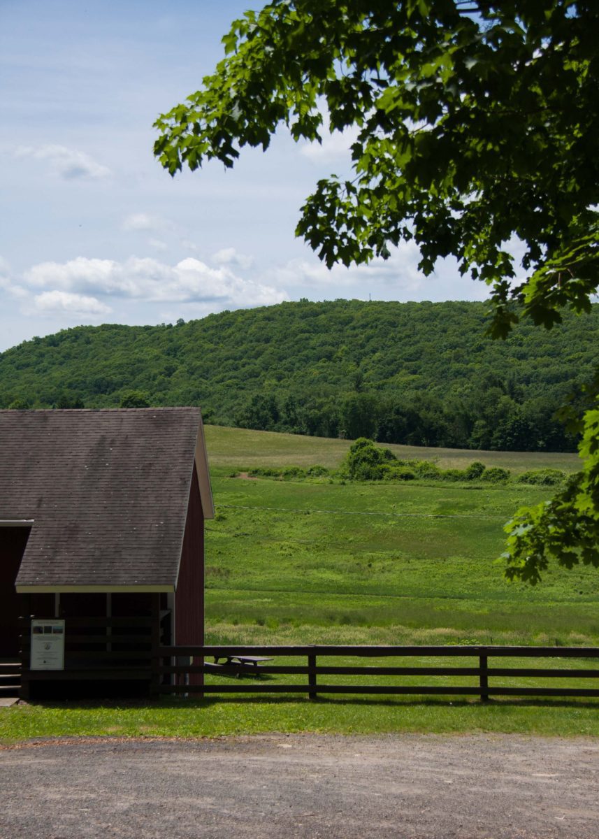 view of red barn with hayfields beyond