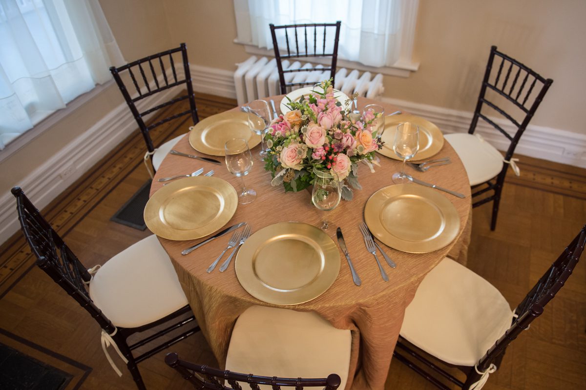 gold plates on round table with flowers