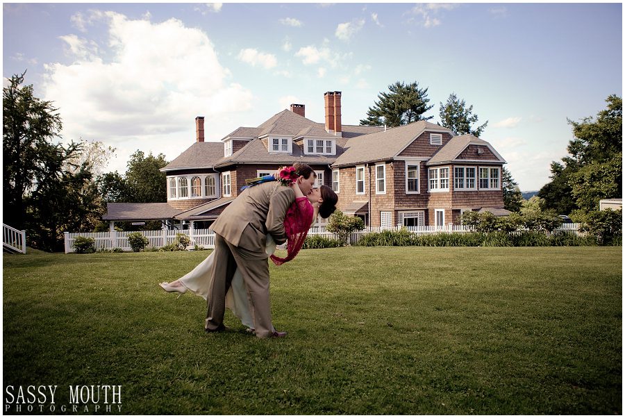 groom dipping bride for kiss in front of mansion