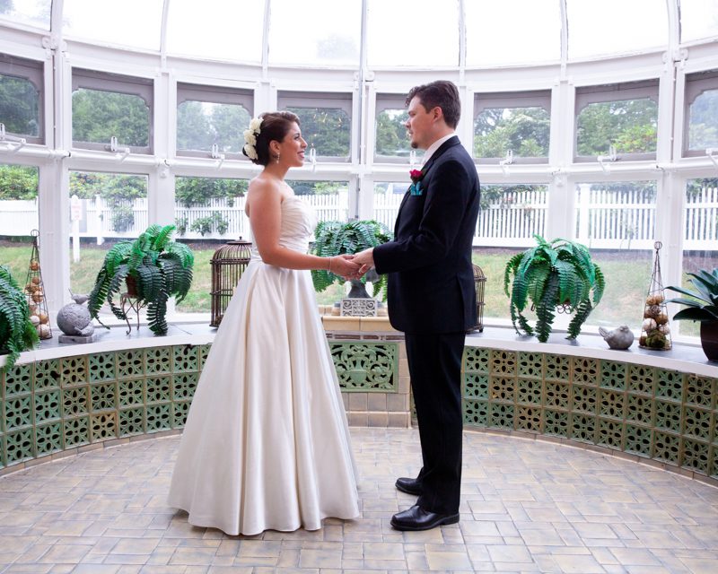 cuban-flair-wedding-rachel-robert-holdiing-hands-in-glass-conservatory