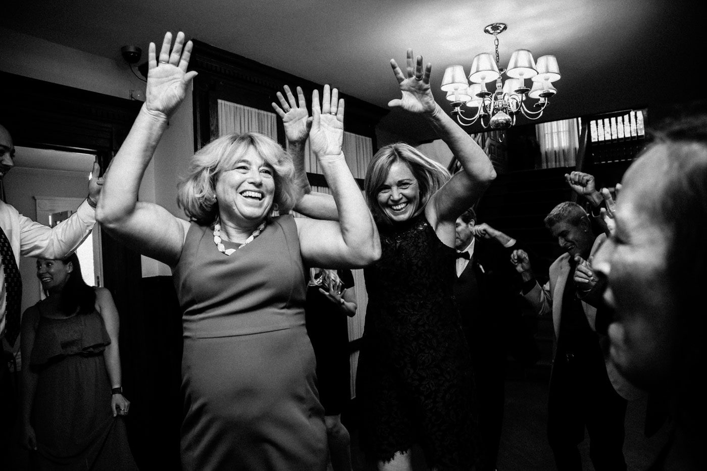 two women dancing with hands in air at wedding