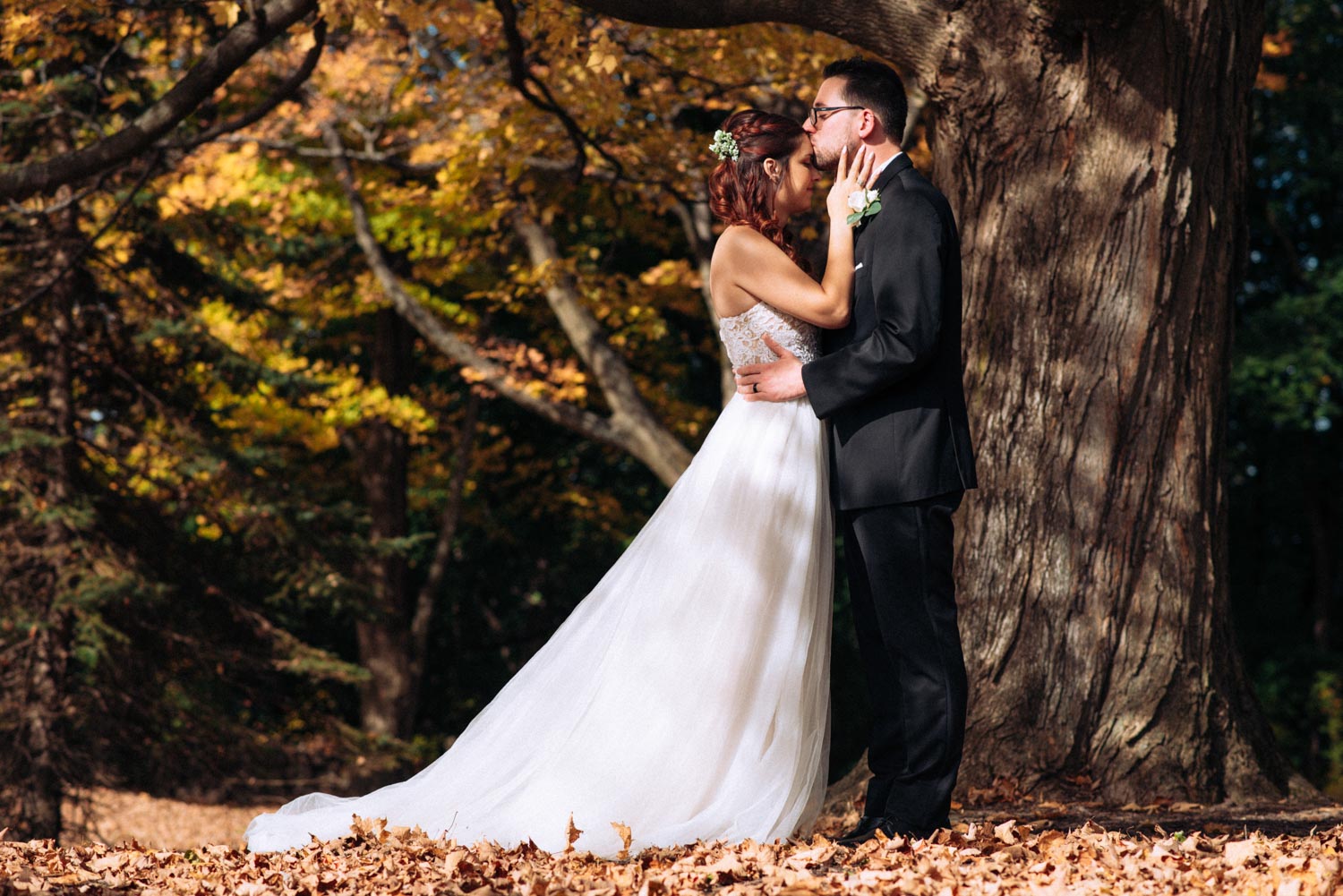 october-wedding-referral-couple-embrace-by-tree